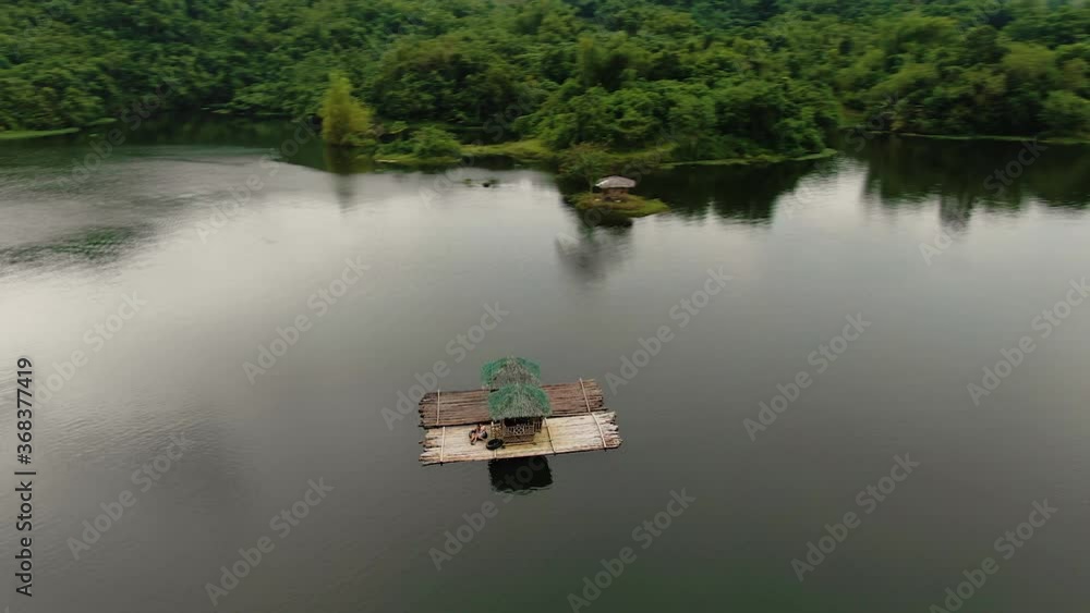 Flying around raft with small huts on, on a small reservoir, lake surrounded by mountains, location the Philippines Flying around raft with small huts on, on a small reservoir, lake surrounded by mountains, location the Philippines