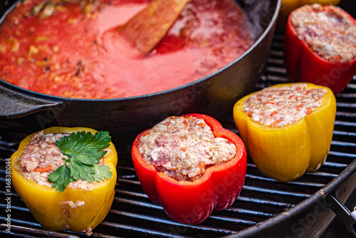 chef making stuffed pepper with tomato sauce