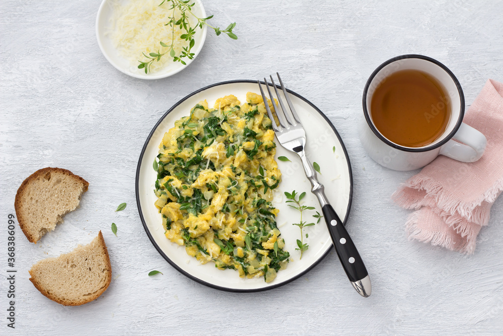 Scrumble eggs with kale and cheese on a light gray background, top view. delicious homemade breakfast Scrumble eggs with kale and cheese on a light gray background, top view. delicious homemade breakfast