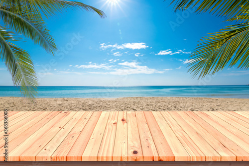 Wooden floor or plank on sand beach in summer. For product display.Calm Sea and Blue Sky Background. © satit