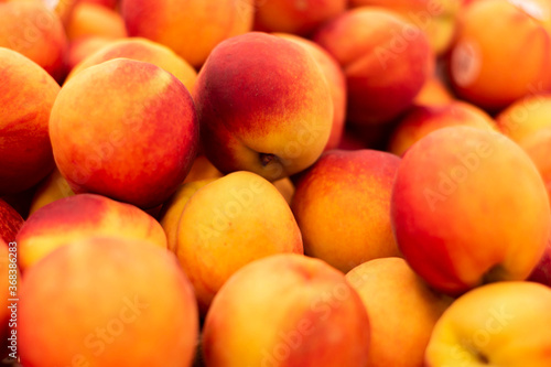 A pile of fresh peaches in the grocery store produce section 