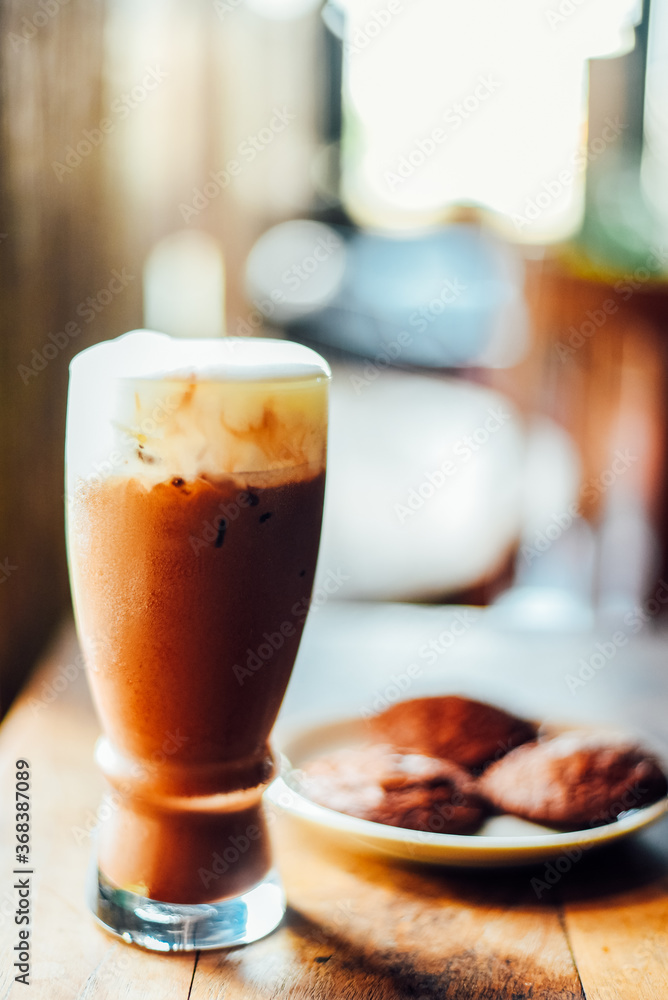 Iced cocoa drink with whipped cream and Brownie cookies on wood table. Iced cocoa drink with whipped cream and Brownie cookies on wood table.