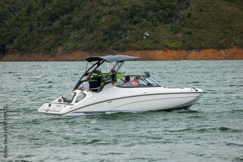 family ridding a white boat at lake calima