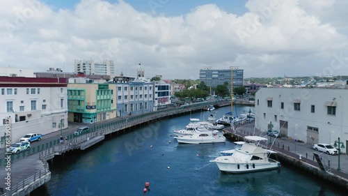 Aerial drone camera moves along Constitution River with yachts in Bridgetown, Barbados