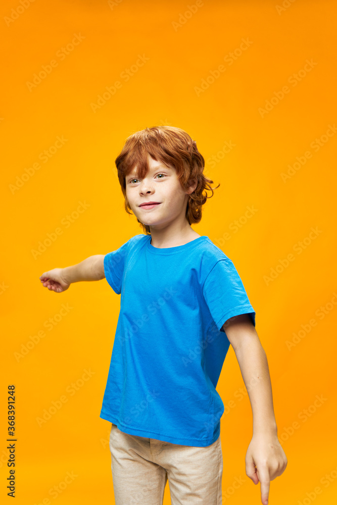 Red-haired boy in a blue T-shirt and light trousers Red-haired boy in a blue T-shirt and light trousers
