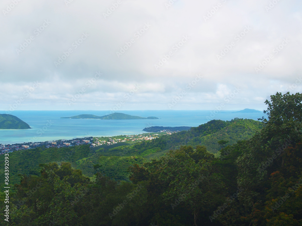 Amazing view from the top of Nakkerd Hills between Chalong and Kata to islands, blue sea, bay. Green forest, rainforest, jungle. Coastal town. Phuket island, Thailand. Sky, clouds. Thai rainy season