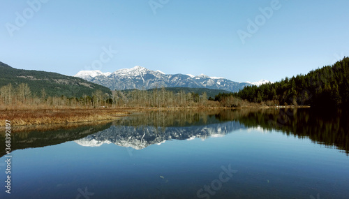 a tranquil scene of One Mile Lake with the reflection of the snow covered mountains in British Columbia Canada  road trip  explore the beauty of local area