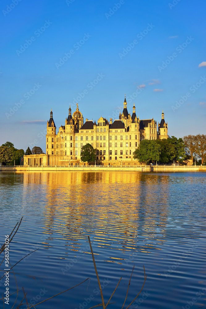 Schwerin Castle with natural sunlight and reflection in the lake.