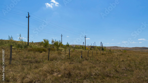 Summer steppe landscape. Landscape in kazakhstan. Kazakh steppe. Power line. Blue sky. Yellow grass. Panorama © Lucky Photographer