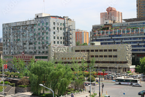 View of the street and interesting buildings of the modern part of the city from the city wall of XI'an against a blue sky with clouds.