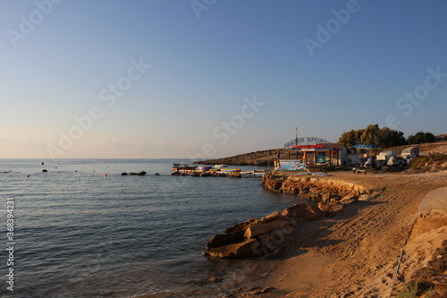 Sandy city beach, turning into a stone, the city of Ayia NAPA against the blue sky.