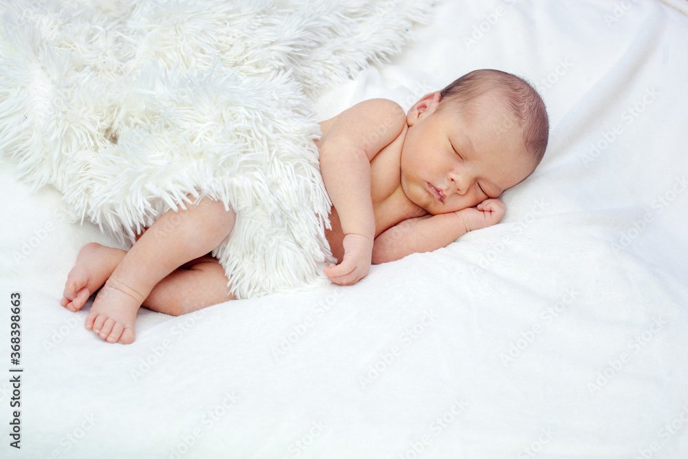 The newborn sleeps peacefully under a fluffy white blanket. The newborn sleeps peacefully under a fluffy white blanket.