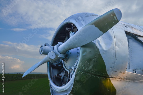 Airplane engine with propeller an old World War 2 plane in a field next to a sunflower field