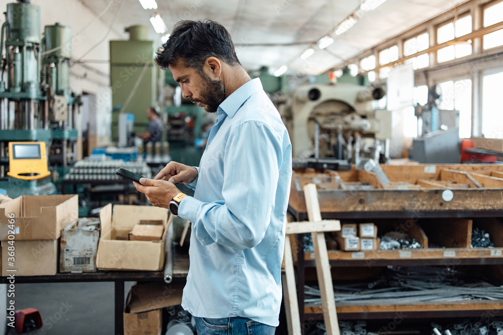 Middle age businessman doing quality control checking at industry production. Factory for industrial production of electric housings and surge arresters. Middle age businessman doing quality control checking at industry production. Factory for industrial production of electric housings and surge arresters.