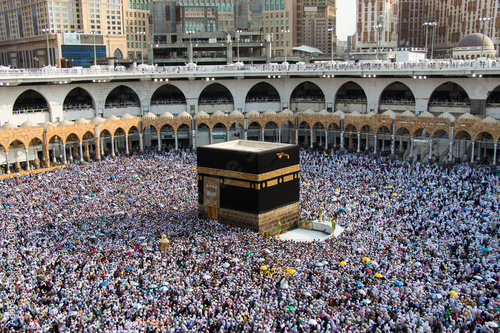 The Holy Kaaba. Crowd of people walking around Kaaba. Tawaf part during Umrah or Hajj