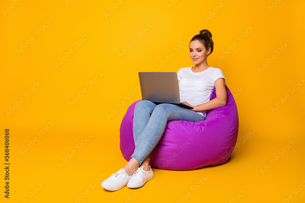 Full size photo of focused smart girl sit purple bag bean work computer read colleagues report document wear style stylish trendy sneakers isolated over bright shine color background Full size photo of focused smart girl sit purple bag bean work computer read colleagues report document wear style stylish trendy sneakers isolated over bright shine color background