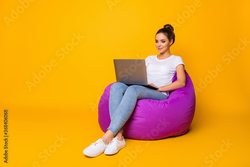 Full size photo of focused smart girl sit purple bag bean work computer read colleagues report document wear style stylish trendy sneakers isolated over bright shine color background