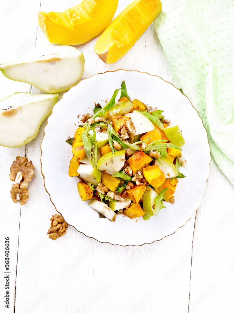 Salad of pumpkin and pear in plate on light board top Salad of pumpkin and pear in plate on light board top