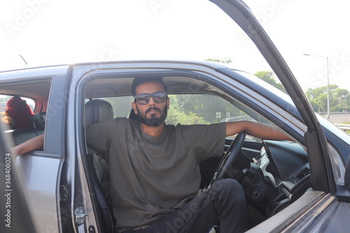 Handsome Indian man sitting inside Car