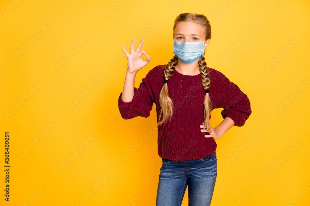 Portrait of her she nice attractive content pre-teen girl wearing safety mask showing ok-sign stop mers cov disease contamination isolated bright vivid shine vibrant yellow color background Portrait of her she nice attractive content pre-teen girl wearing safety mask showing ok-sign stop mers cov disease contamination isolated bright vivid shine vibrant yellow color background