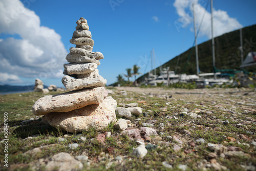 Stones balance on beach and behind hotel resort in blur 