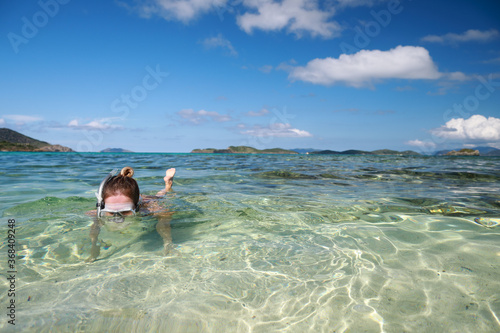 A woman snorkeling in a tropical sea near sandy beach with beautiful color and clear water on Caribbean