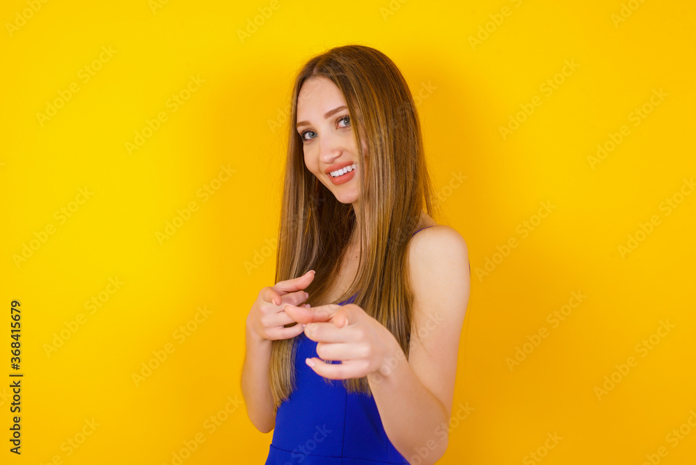 Young beautiful Caucasian woman pointing at camera with index fingers on both hands with happy expression, Good job, I choose you. Copy space. Young beautiful Caucasian woman pointing at camera with index fingers on both hands with happy expression, Good job, I choose you. Copy space.