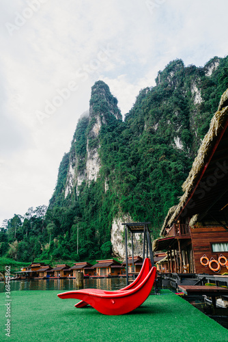 Beautiful view of traditional Thai bungalows with the Limenstone rocks in background at Cheow Lan lake, Ratchaprapha Dam, Khao Sok National Park in Thailand. photo