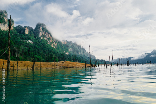 Beautiful view of traditional Thai bungalows with the Limenstone rocks in background at Cheow Lan lake, Ratchaprapha Dam, Khao Sok National Park in Thailand. photo