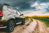 Car Renault Duster Or Dacia Duster Suv In Summer Rapeseed Field Countryside Landscape On Background Dramatic Sky