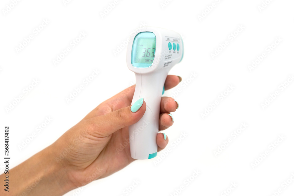Non-contact gun thermometer in a female hand on a white background Non-contact gun thermometer in a female hand on a white background