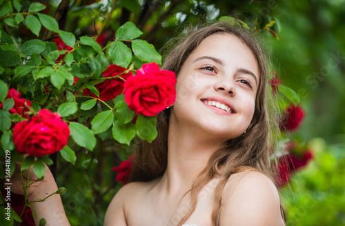 Impossible to hide her happiness. child enjoy blossom in park. small angel for bride. cute lady. happy childhood. beauty and fashion. pretty kid smell rose flower. spring and summer nature © be free