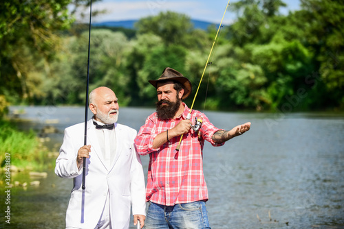 Good day for fishing. hobby of businessman. retirement fishery. happy fishermen in water. friends men with fishing rod and net. Fly fishing adventures. retired father and mature son with beard