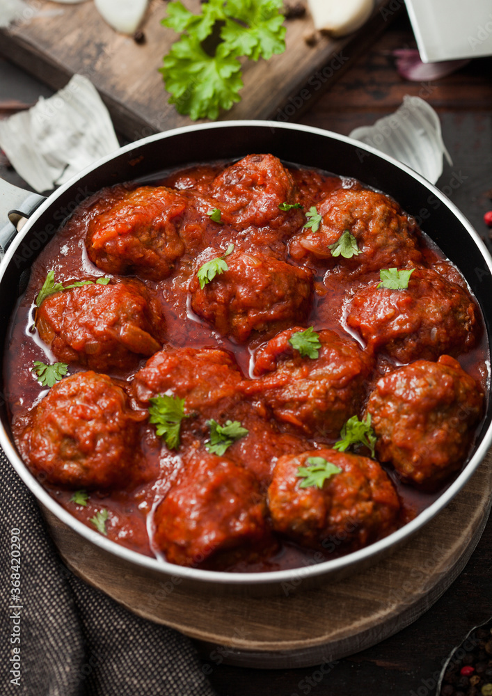 Traditional spicy meatballs in tomato sauce with pepper, garlic and parsley Traditional spicy meatballs in tomato sauce with pepper, garlic and parsley