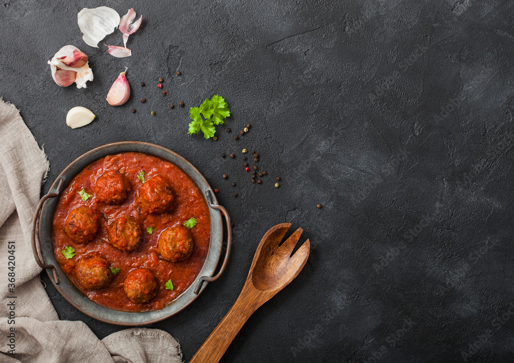 Traditional spicy meatballs in tomato sauce with pepper, garlic and parsley
