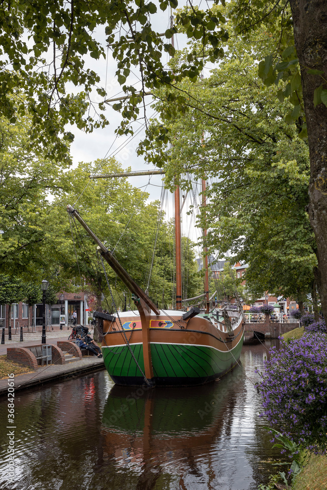 City of Papenburg Germany. Canal and flowers. Bridge and old boat. Sailingship. City of Papenburg Germany. Canal and flowers. Bridge and old boat. Sailingship.
