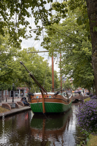Fototapeta Naklejka Na Ścianę i Meble -  City of Papenburg Germany. Canal and flowers. Bridge and old boat. Sailingship.