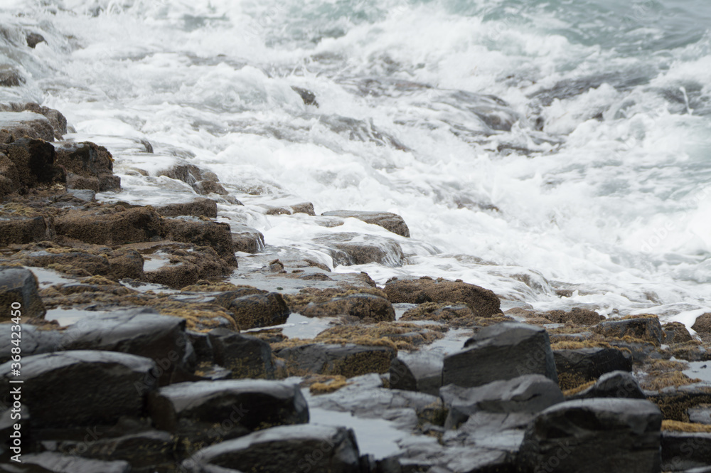 Waves crashing against rocks at the Giant's Causeway, Northern Ireland.