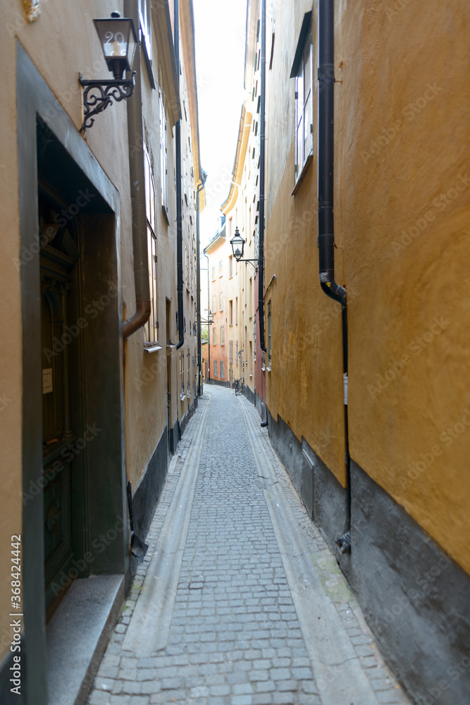 Empty narrow alley of yellow vintage buildings in Sweden