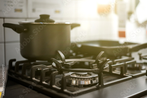 Various modern kitchen elements such as gas stove, pot and pan. Cooking concept. Nice lighting. Soft focus
