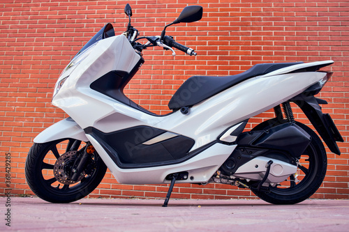 A white motorbike with rusty White motorcycle with a brick wall background
