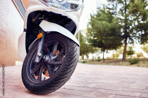 Detail of a motorcycle wheel in the foreground.