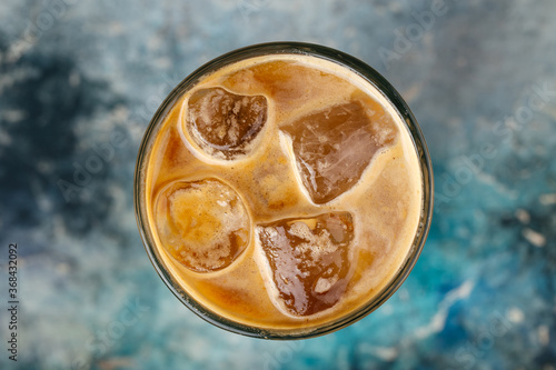 Iced coffee in a glass on the blurry background