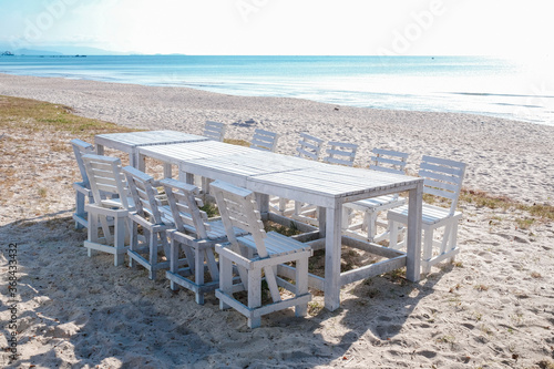 A white wooden table and chairs on the beach