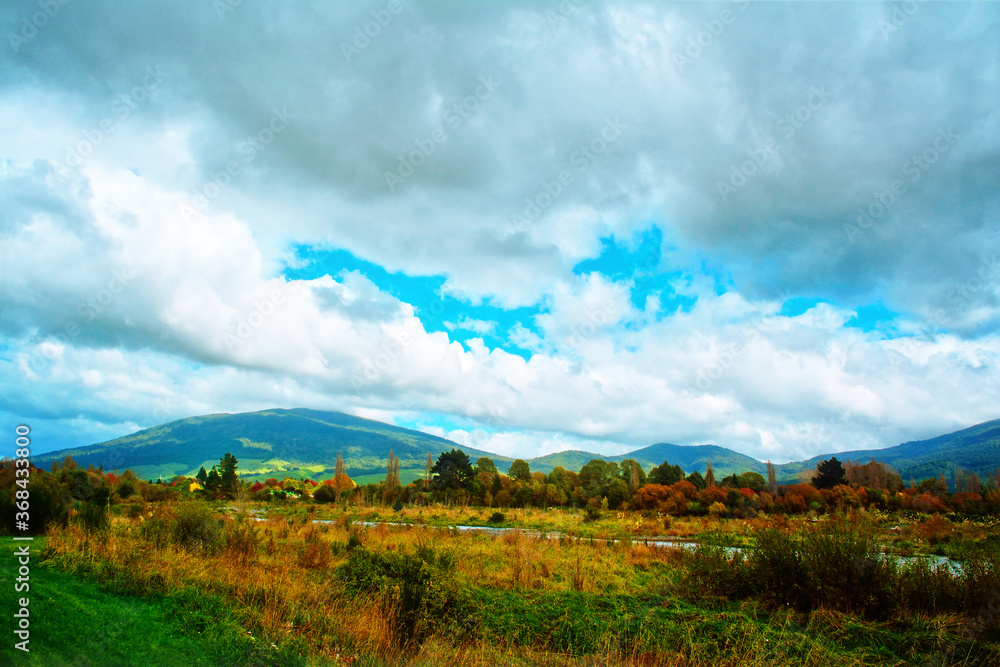 View over Tongariro river valley with beautiful mountains in the background on a bright autumn day. North Island, New Zealand View over Tongariro river valley with beautiful mountains in the background on a bright autumn day. North Island, New Zealand