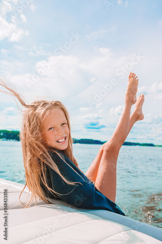 Little girl sailing on boat in clear open sea photo