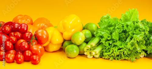 Fototapeta Naklejka Na Ścianę i Meble -  A set of vegetables lies on a yellow background. Tomatoes, peppers, limes and celery.