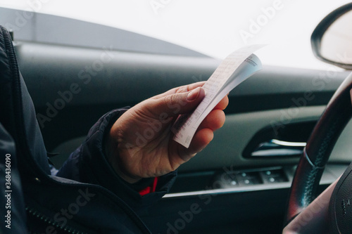a man in a car holding a receipt