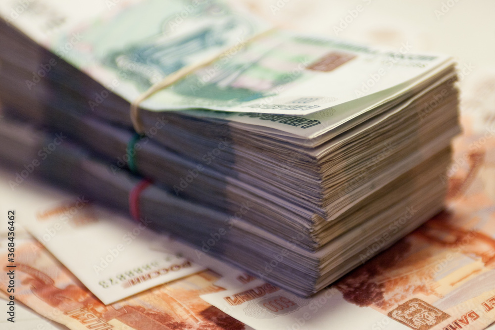 A bundle of banknotes on the background of other banknotes. 1000 and 5000 rubles A bundle of banknotes on the background of other banknotes. 1000 and 5000 rubles