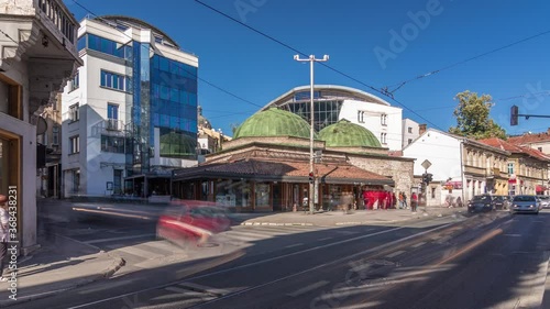 Bosniak Institute timelapse hyperlapse, in a renovated Turkish bathhouse, includes a library and art collection focusing on Bosniak culture. Street with cars and public transport at Sarajevo city photo